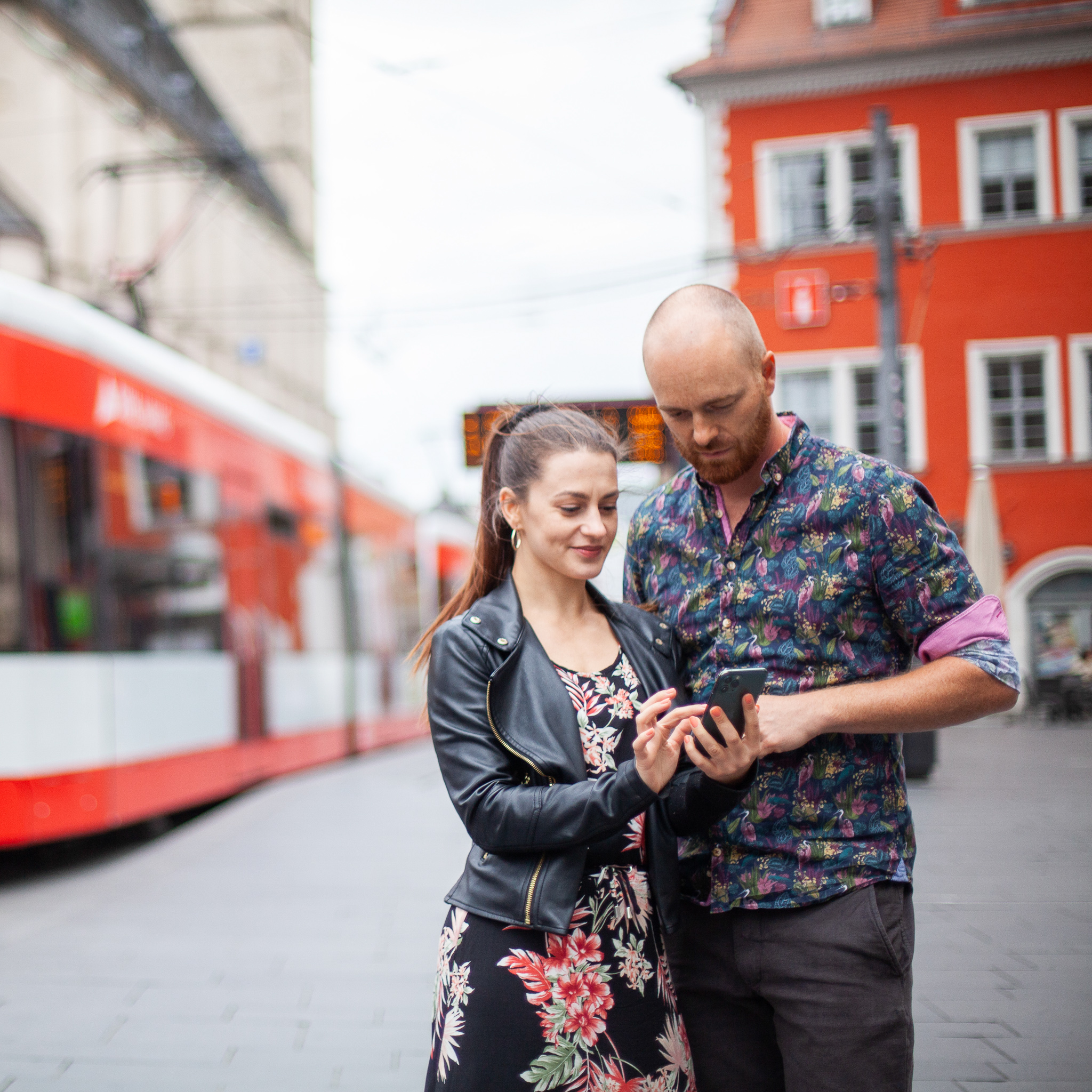 Stadtwerke Halle Mein HALLE Marktplatz Ein Mann und eine Frau stehen auf dem Marktplatz in Halle und schauen gemeinsam auf ein Smartphone.